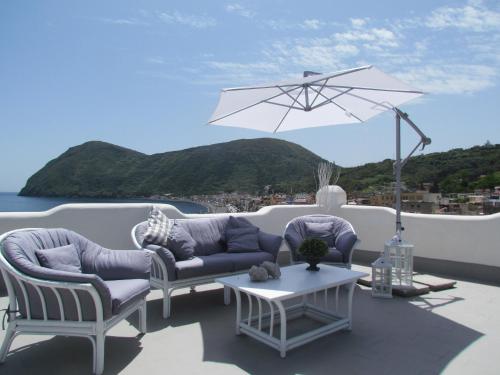 a patio with two chairs and a table and an umbrella at Hotel Odissea in Canneto