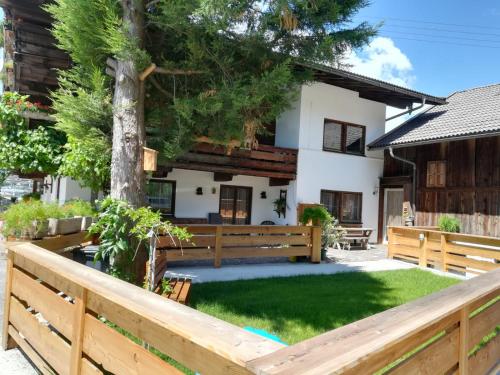 a house with a fence and a tree at Come In in Buch bei Jenbach