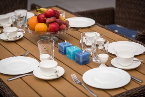 a table with white plates and a bowl of fruit at Kapitaensweg 12 in Ostseebad Karlshagen