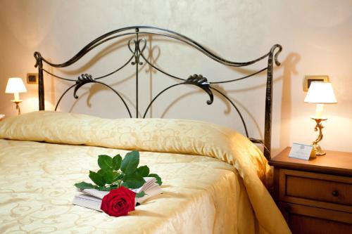 a red rose sitting on top of a bed at Hotel Villa Torre Antica in Atena Lucana