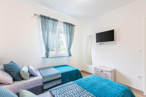 a living room with a couch and a tv at Lux Apartment Medulin Istria in Medulin