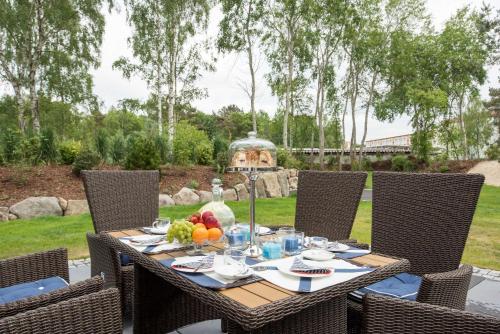 an outdoor table with chairs and fruit on it at Kapitaensweg 12 in Ostseebad Karlshagen