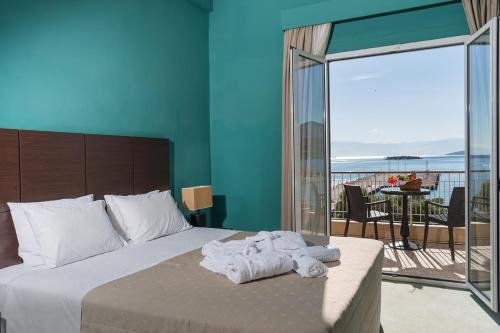 a bedroom with a bed with towels and a balcony at Galini Hotel in Itea
