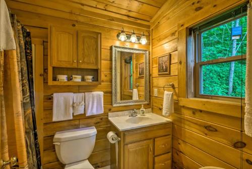 a bathroom with a toilet and a sink and a mirror at Nantahala Cabins in Bryson City