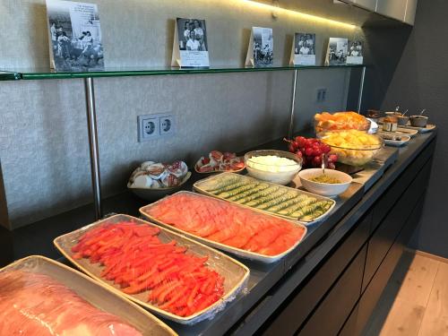 una línea de buffet con diferentes tipos de comida en bandejas en Hotel Isafjordur - Horn, en Ísafjörður