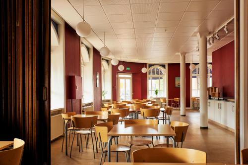 Danhostel Odense City في أودنسه: غرفة طعام مليئة بالطاولات والكراسي