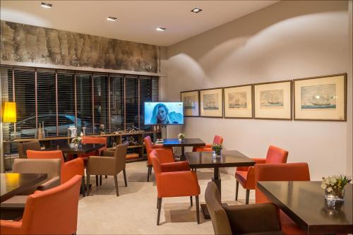 a restaurant with tables and chairs and a flat screen tv at Galini Hotel in Itea