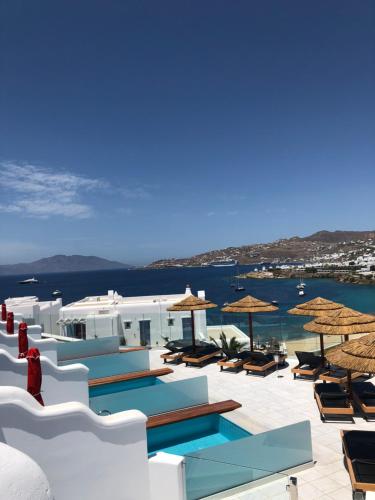 a resort with a pool and chairs and umbrellas at Grand Beach Hotel in Mýkonos City
