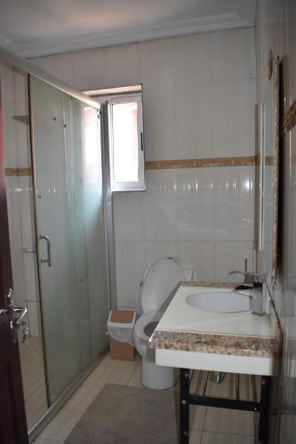 Un baño con inodoro, lavabo y ducha. en Cascade Hotel, en Chantan