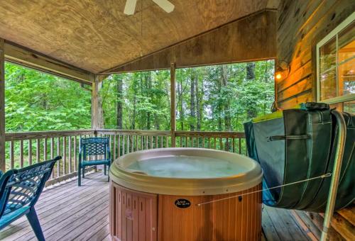 a jacuzzi tub on a deck with two chairs at Nantahala Cabins in Bryson City
