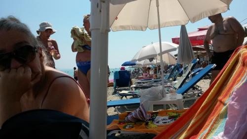 a woman talking on a cell phone at the beach at Polichrono in Polykhrono