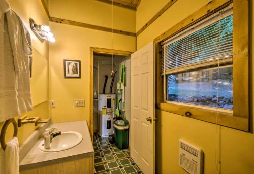a yellow bathroom with a sink and a window at Nantahala Cabins in Bryson City