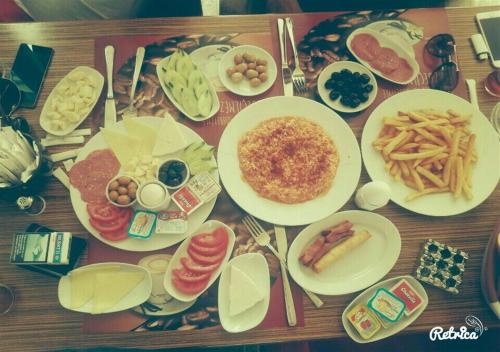 a wooden table topped with plates of breakfast food at Blue Vip House in Beylikduzu