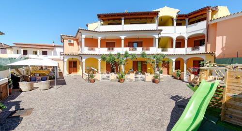 a large building with a playground in front of it at Residence La Corte Di Anastasia in Torpè