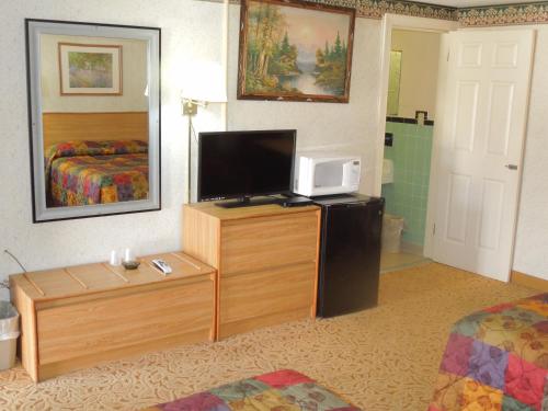 une chambre d'hôtel avec une télévision et une chambre dans l'établissement Red Lion Motel Southampton, à Southampton