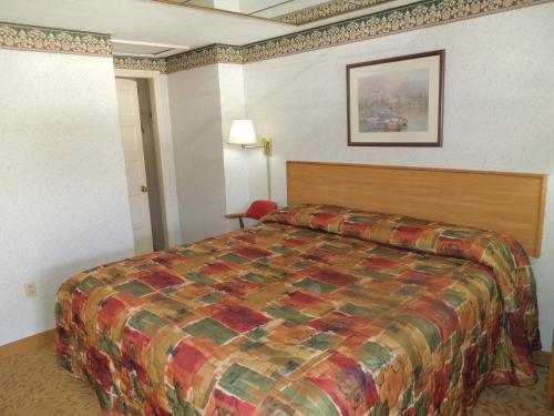 una habitación de hotel con una cama y una foto en la pared en Red Lion Motel Southampton, en Southampton