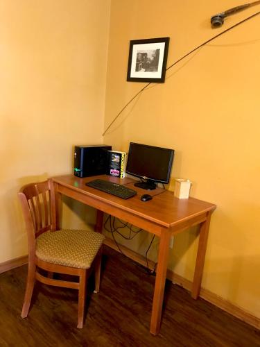 a wooden desk with a computer and a chair at FairBridge Inn & Suites Kellogg in Kellogg