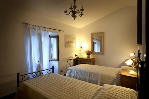 a bedroom with two beds and a chandelier at La Corte Di Nando in Varzi