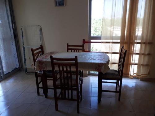 d'une salle à manger avec une table, des chaises et une fenêtre. dans l'établissement Boshku apartament, à Durrës