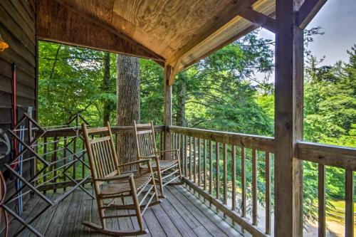 two chairs on the porch of a cabin in the woods at Nantahala Cabins in Bryson City