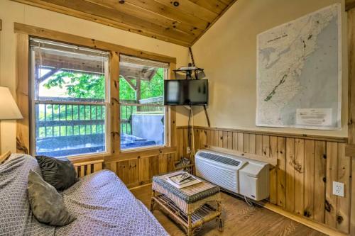 a room with a bed and a tv and a window at Nantahala Cabins in Bryson City