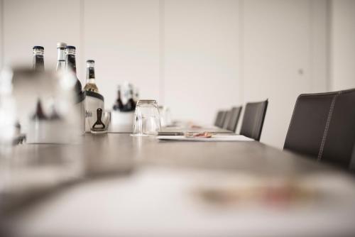 a long table with bottles and glasses on it at Hotel Linde in Günzburg