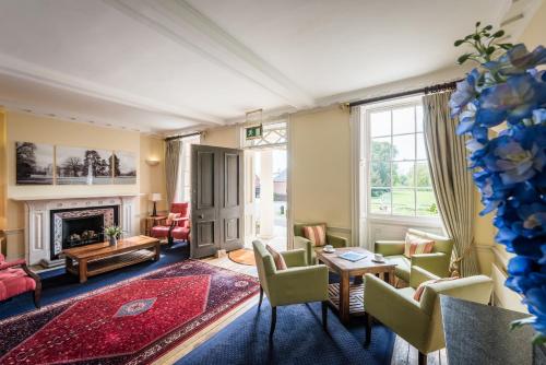 a living room with chairs and a fireplace at Hinxton Hall Conference Centre in Hinxton
