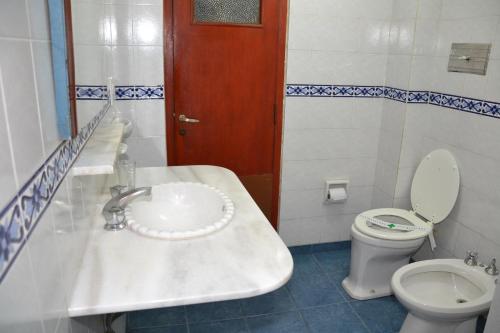 y baño con lavabo y aseo. en Hotel Regidor en Salta