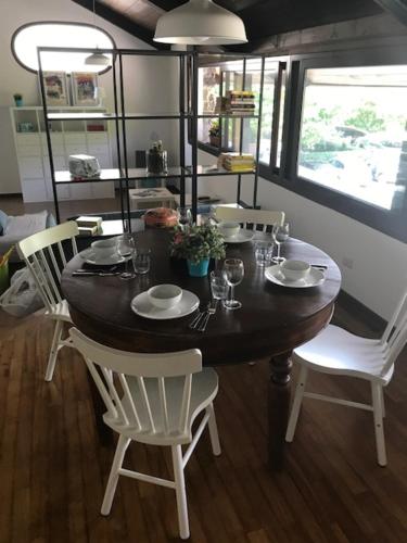 a dining room table with white chairs and a table and chairsktop at Appartamenti I Giardini Di Villa Melzi in Bellagio