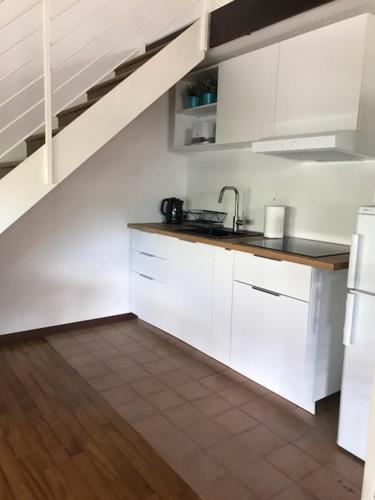 a kitchen with white cabinets and a sink at Appartamenti I Giardini Di Villa Melzi in Bellagio