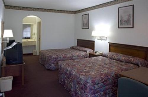 ein Hotelzimmer mit 2 Betten und einem TV in der Unterkunft Budget Host Hempstead Inn Brookhollow/Energy Corridor in Houston
