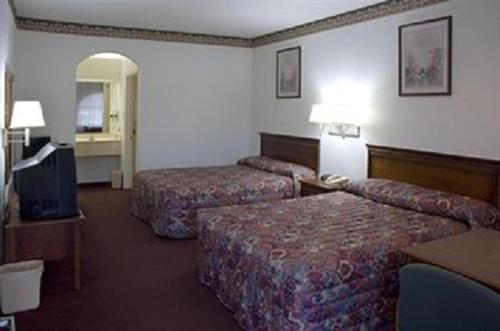 a hotel room with two beds and a television at Budget Host Hempstead Inn Brookhollow/Energy Corridor in Houston