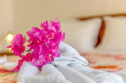 a bunch of pink flowers sitting on top of a bed at Veranda Syros House in Ermoupoli