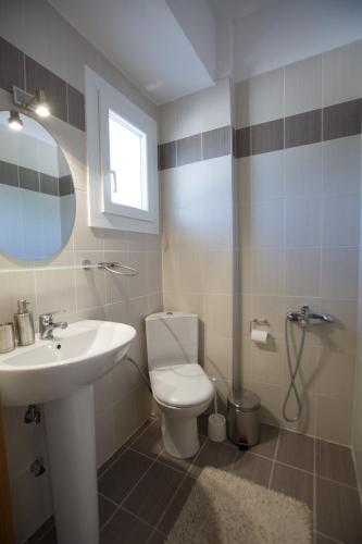 a bathroom with a white toilet and a sink at Deep Purple House 4 in Kriopigi
