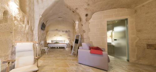 a living room with a couch and a bed in a room at Thymus Residence nei Sassi in Matera