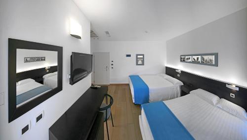 a hospital room with two beds and a tv at Hotel Europa Monetti in Cattolica