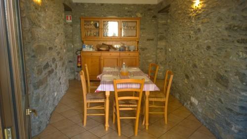 una cucina con tavolo e sedie in una stanza di Locanda Nonno Puin a Moconesi