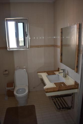 a bathroom with a toilet and a sink and a window at Cascade Hotel in Chantan