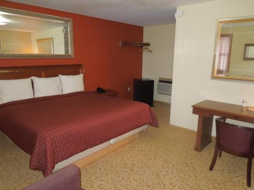 Habitación de hotel con cama y escritorio en Slumberland Motel Mount Holly, en Mount Holly