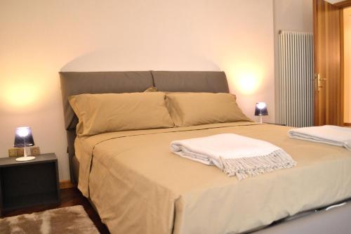 a bedroom with a bed with two towels on it at Portico Oscuro Deluxe Apartment - centro città in Treviso