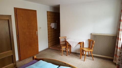 a small room with a table and two chairs and a door at Junser Gasthausl in Tux