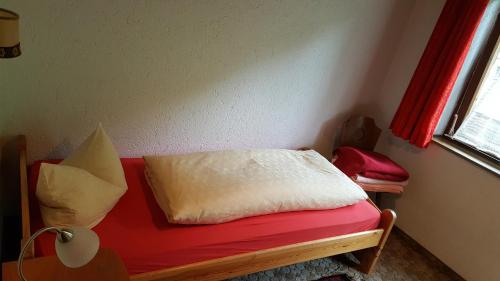 a room with a red bench with a pillow on it at Junser Gasthausl in Tux