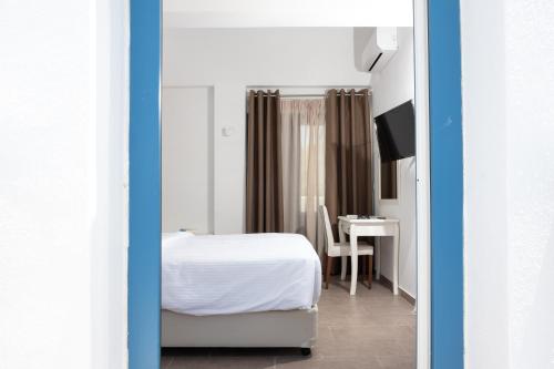 a bedroom with a bed and a table with a desk at Tristhenia in Perissa