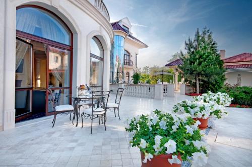 a patio with a table and chairs and flowers at Villa Le Premier - Maestro in Odesa