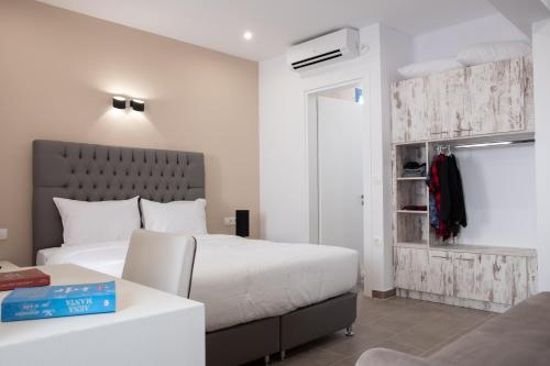 a bedroom with a large white bed and a table at Tristhenia in Perissa