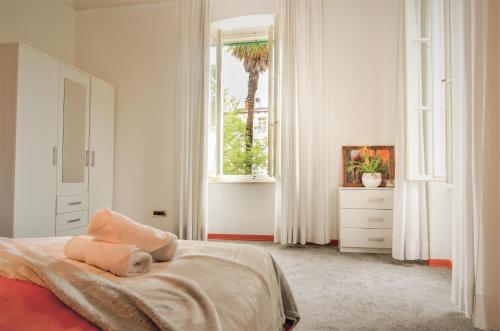a white bedroom with a bed and a window at Villa Palma in Opatija