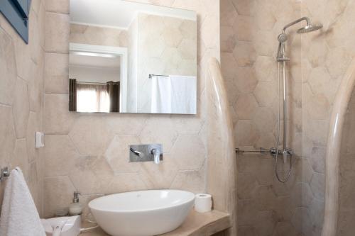 a bathroom with a sink and a shower at Tristhenia in Perissa