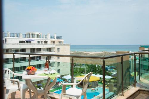 a balcony with a table and chairs and the ocean at Aparthotel Hotel Prestige City II in Primorsko