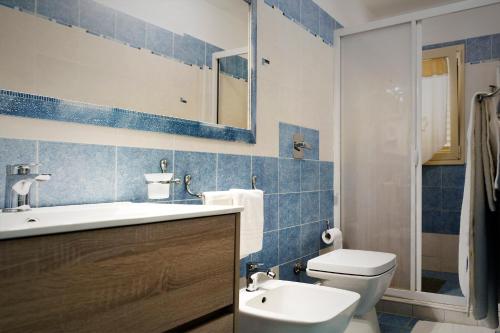 a blue and white bathroom with a toilet and a sink at Terrazza a mare Corallo in Marina di Ragusa