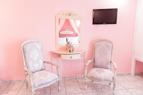 two chairs in a room with a desk and a mirror at Villa Sophia in Mitikas
